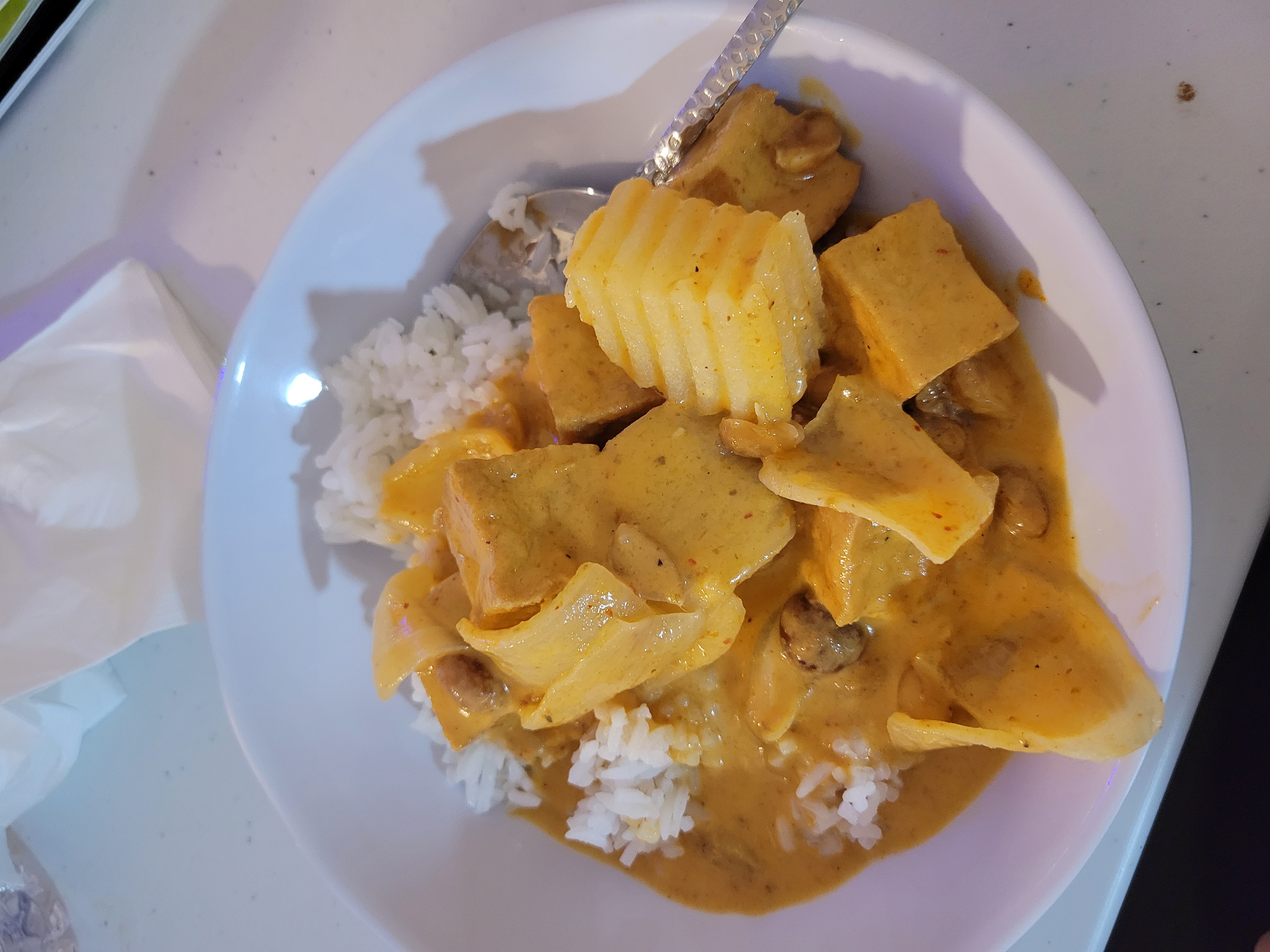 Fried tofu thai curry with rice in a bowl.